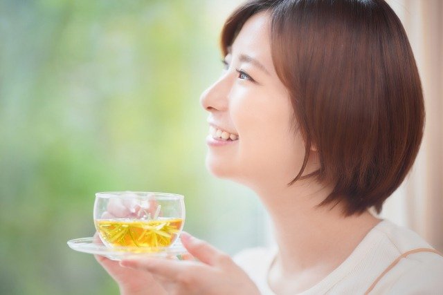 お茶を飲みながら微笑む女性の横顔