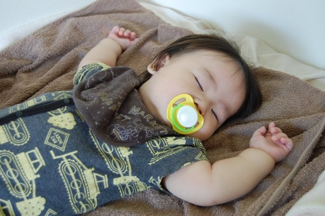 おしゃぶりを加えて眠っている赤ちゃん